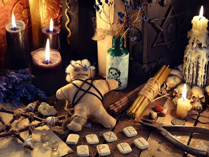 Muñeco ritual atado con hilos y acompañado de runas, usado en algunos hechizos de amor